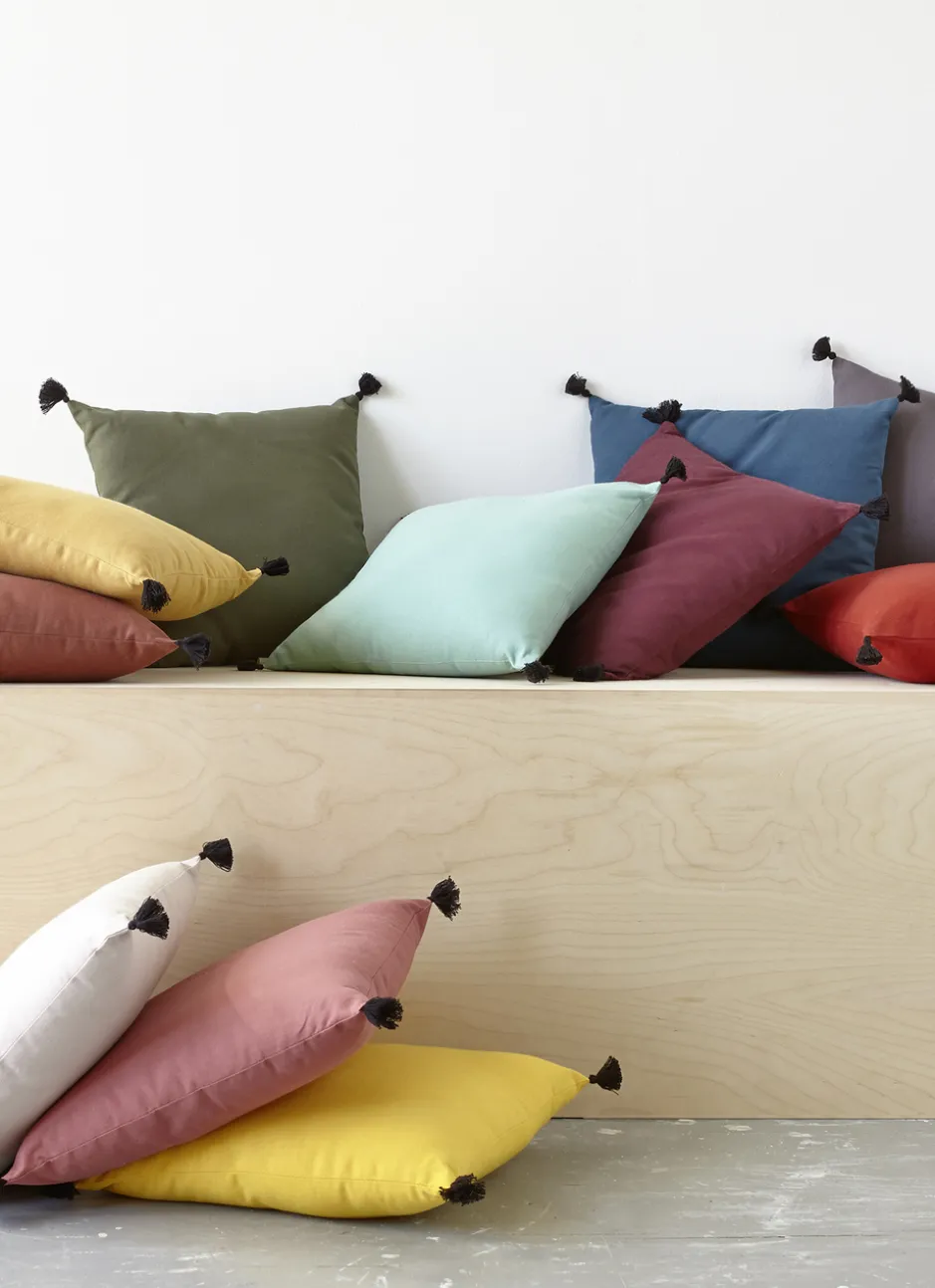 COUSSIN EN COTON UNI AVEC PETITS POMPONS ROUILLE